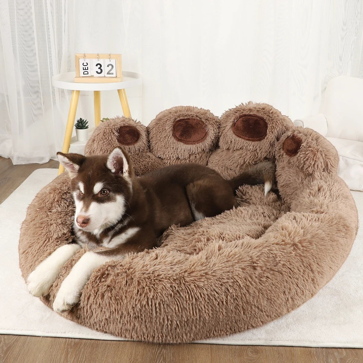 Panier Pelorie moelleux en forme de patte marron avec un chiot husky confortablement installé à l'intérieur
